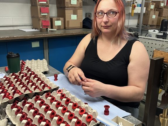 Assembly worker inspecting aluminium anodised parts